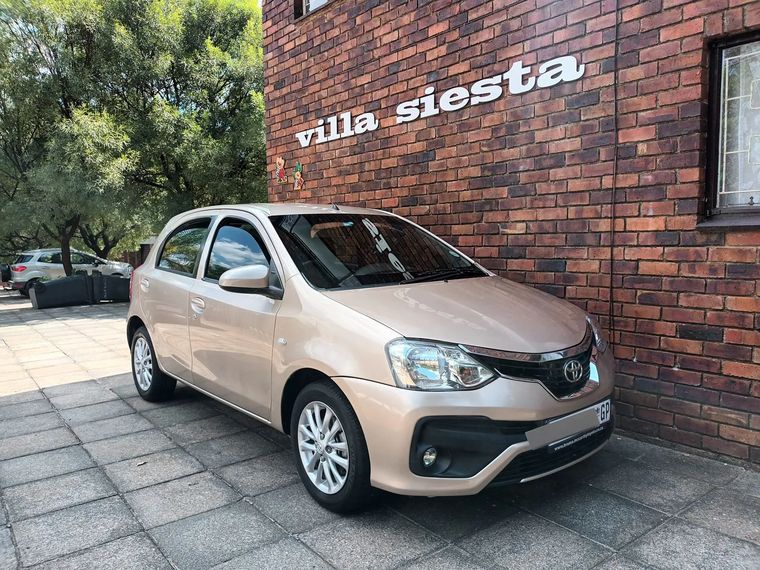 The same Etios finished in champagne, parked outside