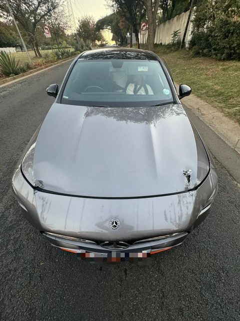 A grey Mercedes CLA from the front, showing bonnet damage