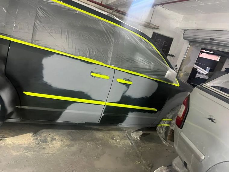 A black MPV with side panels in primer and taped off